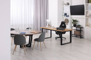 Rahat mobilyaları ve televizyon sahası olan şık bir ofis. İç tasarım