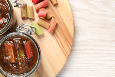 Kavanozlar dolusu lezzetli ravent reçeli ve beyaz ahşap masa sapları, üst manzara. Metin için boşluk