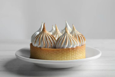 Beyaz ahşap masada kremalı tart, yakın plan. Lezzetli tatlı