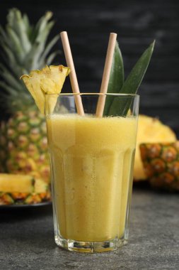 Lezzetli ananas püresi ve dilimlenmiş meyve gri masada, yakın plan.