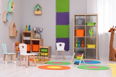 Farklı oyuncakları ve mobilyaları olan çocuk oyun odası. Sıcak anaokulu iç mimarisi.