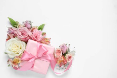 Hediye kutusu ve beyaz arka planda güzel çiçekler. Metin için boşluk