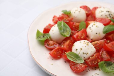 Domatesli Caprese salatası, mozzarella topları ve beyaz fayanslı fesleğen, yakın plan. Metin için boşluk