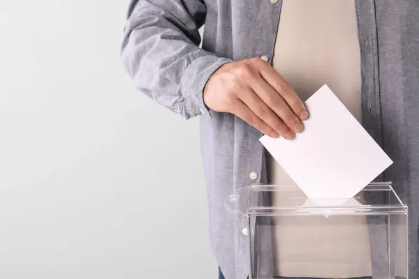 stock image Man putting his vote into ballot box on light grey background, closeup. Space for text