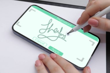 Elektronik imza. Stylus ve cep telefonu kullanan kadın, yakın plan