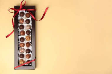 Bej masa üzerinde nefis çikolata şekerlemeleri olan bir kutu, üst manzara. Metin için boşluk
