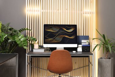 Evdeki metal masada bilgisayarı olan rahat çalışma alanı