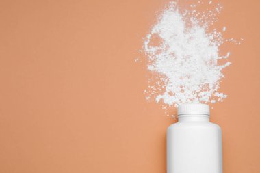 Soluk mercan zemin üzerinde şişe ve toz alma tozu, üst görünümü metin için alan. Bebek kozmetik ürünü