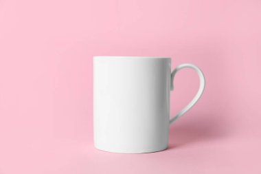 Pembe arka planda beyaz bir seramik bardak.