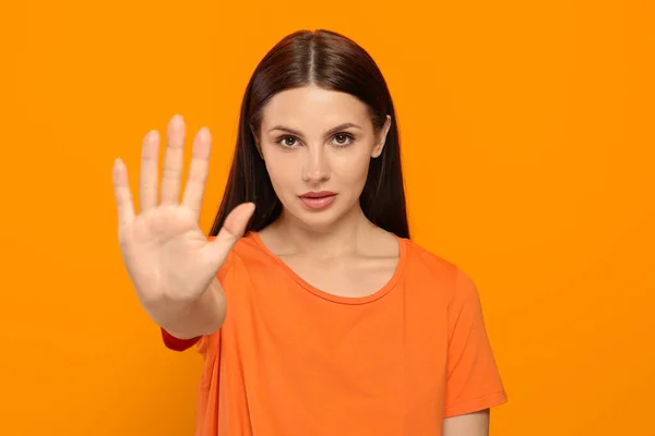 Frau Zeigt Stop Geste Auf Orangefarbenem Hintergrund — Stockfoto