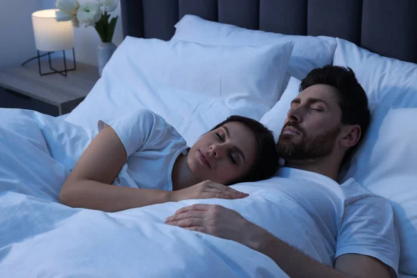 Lovely couple sleeping together in bed at night