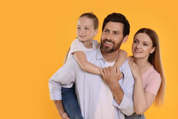 Happy family on orange background, space for text