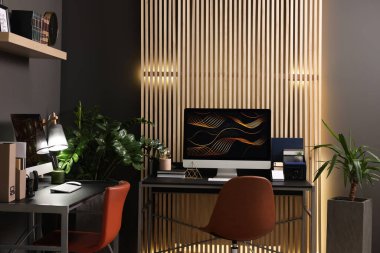 Evdeki metal masada bilgisayarı olan rahat çalışma alanı