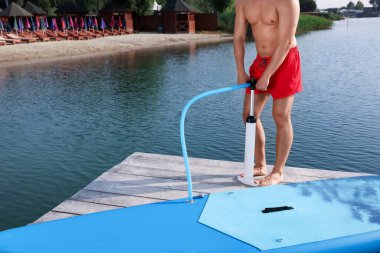 İskelede SUP panosunu dolduran adam, yakın plan.