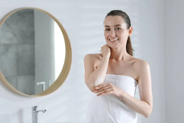 快乐的女人在浴室的肘部涂上护肤霜 留有文字空间 — 图库照片