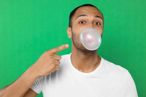 Portrét Muže Foukání Žvýkačky Zeleném Pozadí — Stock fotografie