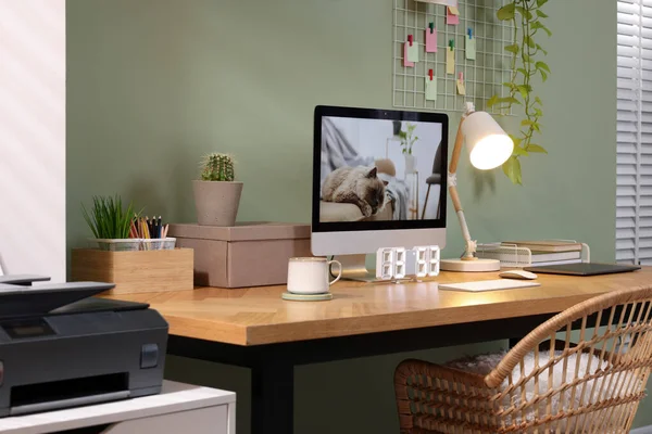 在家里的橄榄墙边 有电脑 笔记本电脑和灯的时尚工作场所 — 图库照片
