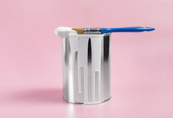 stock image Can of white paint and brush on pink background