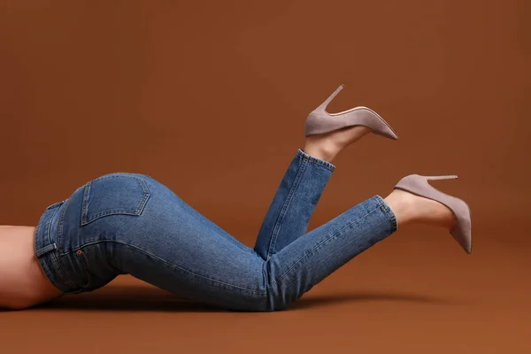 茶色の背景にスタイリッシュなジーンズの女性 クローズアップ — ストック写真