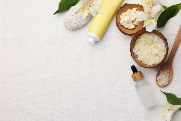 Flat lay composition with spa products and leaves on white towel. Space for text