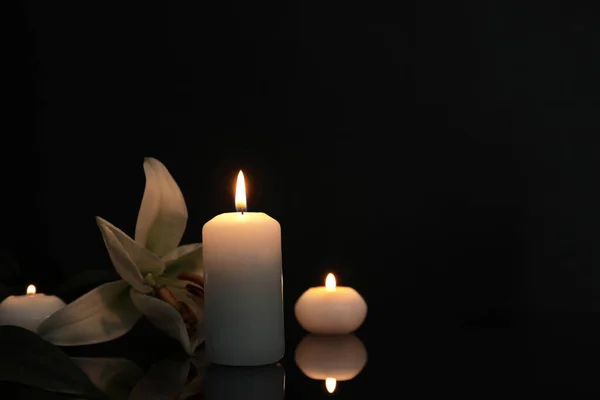 Weiße Lilie Und Brennende Kerzen Auf Schwarzer Spiegelfläche Der Dunkelheit — Stockfoto