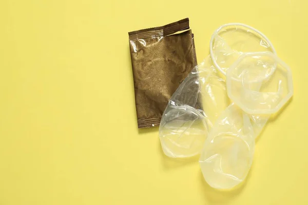 Rozvinuté Ženské Kondomy Potrhaný Balíček Žlutém Pozadí Plochý Ležel Prostorem — Stock fotografie