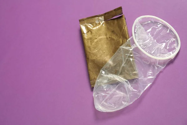 Ovalsad Kvinnlig Kondom Och Trasiga Paket Violett Bakgrund Ovan Visa — Stockfoto