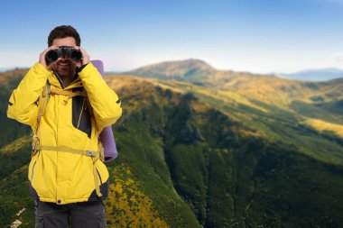 Sırt çantalı ve dürbünlü bir turist dağlarda