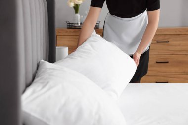 Oda hizmetçisi otel odasında yatak yapıyor, yakın plan.