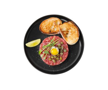 Lezzetli biftekli tart, bıldırcın yumurtası, tost ekmeği ve beyaza izole edilmiş diğer aksesuarlarla servis edilir.