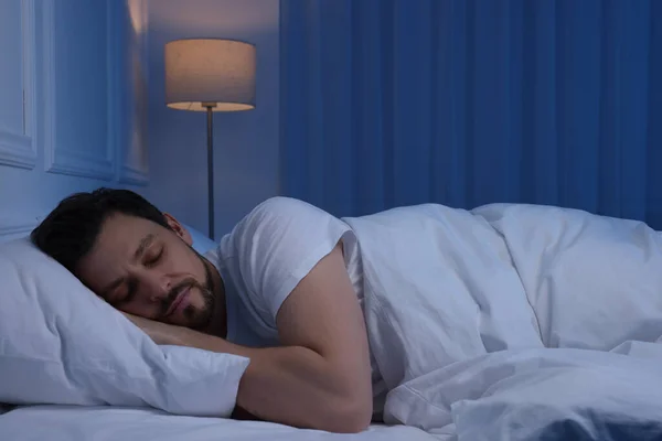 stock image Handsome man sleeping in bed at night