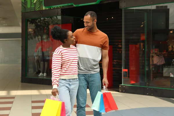 Family shopping. Happy couple with colorful bags in mall