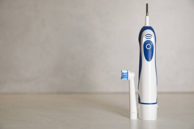 Açık arkaplanda elektrikli diş fırçası, metin için boşluk