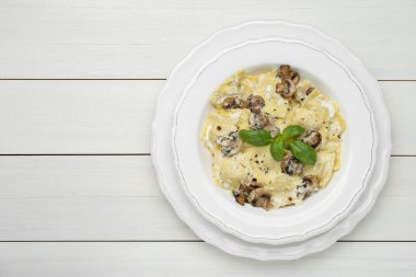 Mantarlı ve peynirli nefis ravioli beyaz ahşap masa, üst manzara. Metin için boşluk