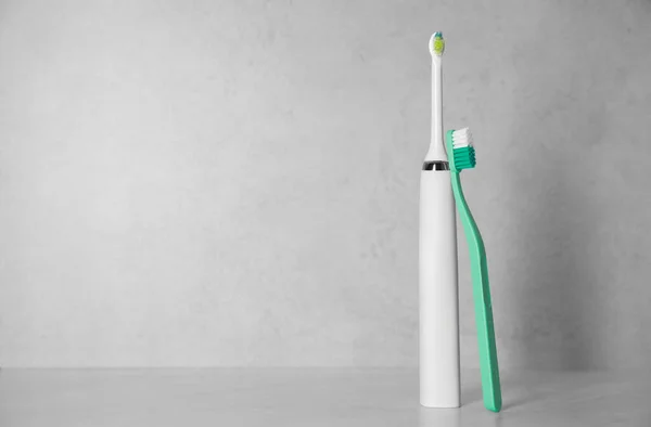 Escovas Dentes Elétricas Plásticas Fundo Claro Espaço Para Texto — Fotografia de Stock
