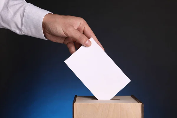 Mann Gibt Seine Stimme Wahlurne Auf Dunkelblauem Hintergrund Nahaufnahme — Stockfoto