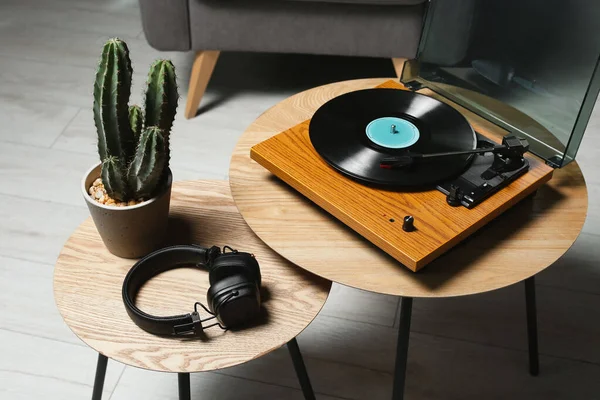 屋内の木のテーブルのビニールの記録 ヘッドホンおよびCactusが付いているスタイリッシュな回転テーブル — ストック写真