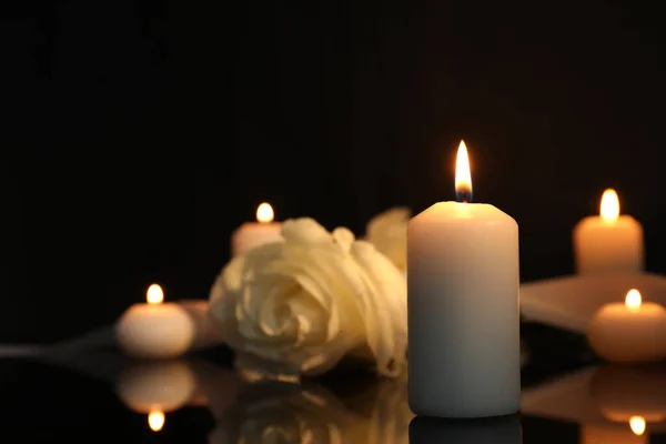 暗闇の中で黒い鏡面に白いバラと燃えるろうそくは テキストのためのスペースで閉じます 葬儀のシンボル — ストック写真