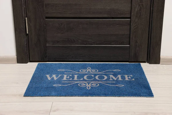 stock image Blue doormat with word Welcome on white floor near entrance