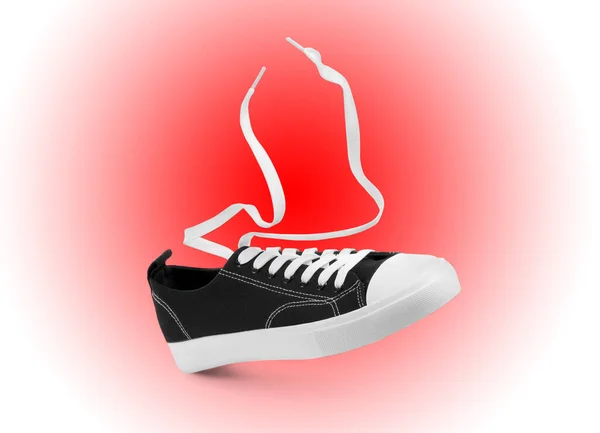 在红色渐变背景的空气中穿上一双时髦的运动鞋 — 图库照片