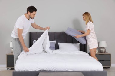 Çift odada çarşaf değiştiriyor. Ev işleri.