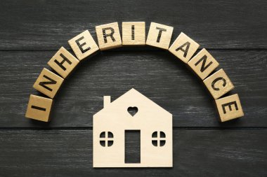 Kelime kalıtımsal küp ve ev modeli siyah ahşap masada, düz yatıyordu.