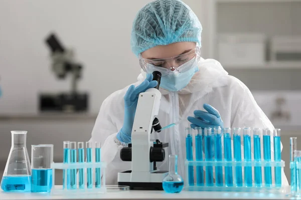 Naukowiec Kapiący Próbkę Płytkę Petriego Podczas Pracy Mikroskopem Laboratorium — Zdjęcie stockowe