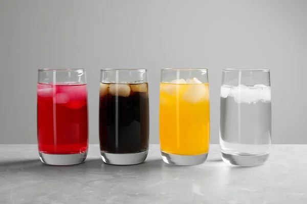 Glazen Van Verschillende Verfrissende Frisdrank Water Met Ijsblokjes Lichtgrijze Marmeren — Stockfoto