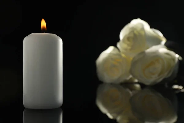 在黑暗中 白色的玫瑰和燃烧的蜡烛在黑色的镜子表面 与文字的空间紧密相连 丧葬标志 — 图库照片