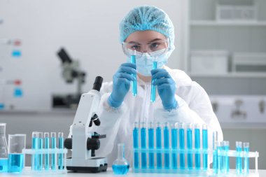 Laboratuvarda test tüplerinde numunelerle çalışan bilim adamları.