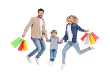 Aile alışverişi. Mutlu ebeveynler ve oğullar beyaz arka planda renkli çantalarla atlıyorlar.