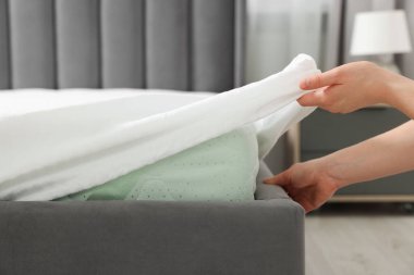Otel odasında yatak hazırlayan hizmetçi, yakın plan. Metin için boşluk