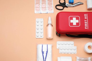 Soluk mercan zemin üzerinde ilk yardım çantasıyla düz kompozisyon. Metin için boşluk