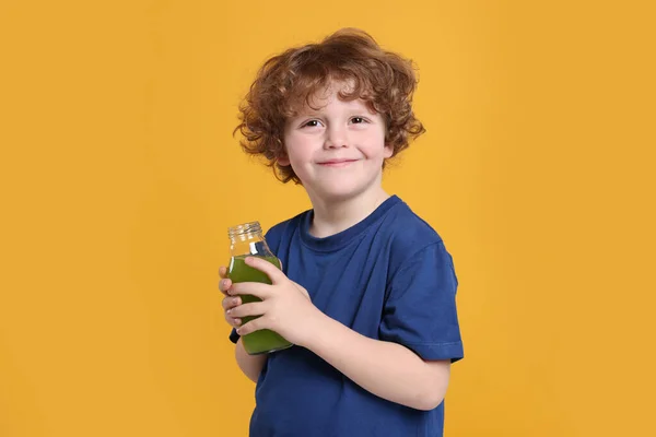Söt Liten Pojke Med Glasflaska Färsk Juice Orange Bakgrund — Stockfoto